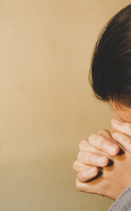 Person praying with clasped hands