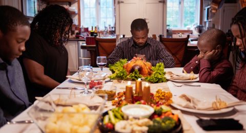 Family giving thanks at dinner table