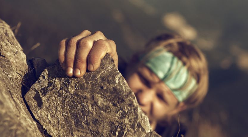 Person climbing rock face outdoors