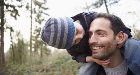 Father carrying young child on shoulders