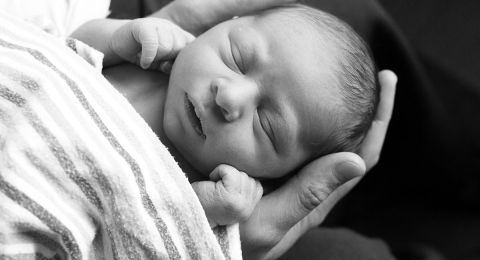 Baby cradled in father's hands