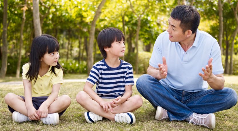 Man teaching two young children