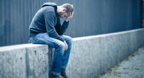 Distressed man with head in hands