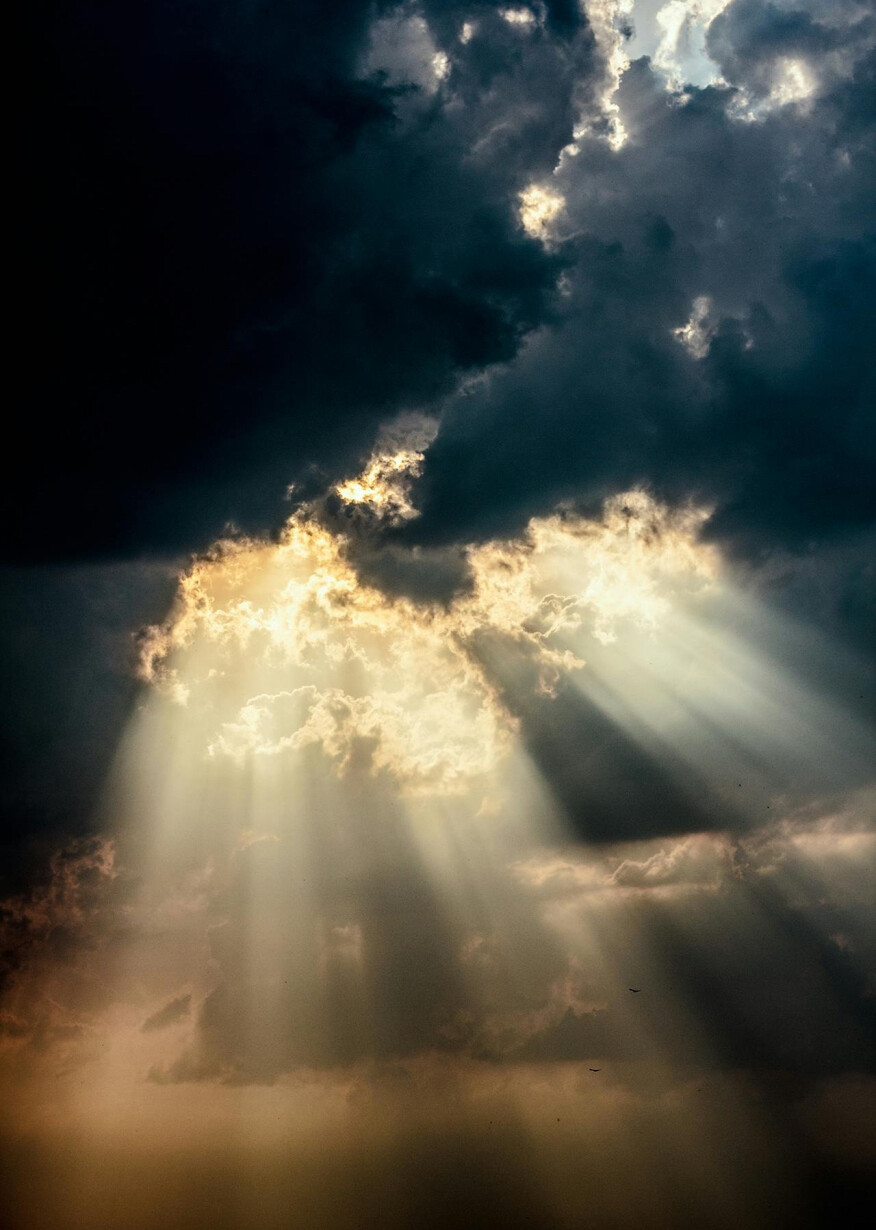 Sunbeams piercing dark storm clouds