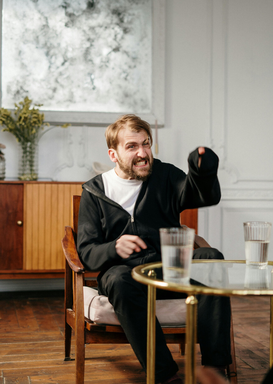 Angry man seated indoors