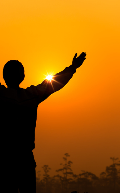 Man silhouetted against orange sky