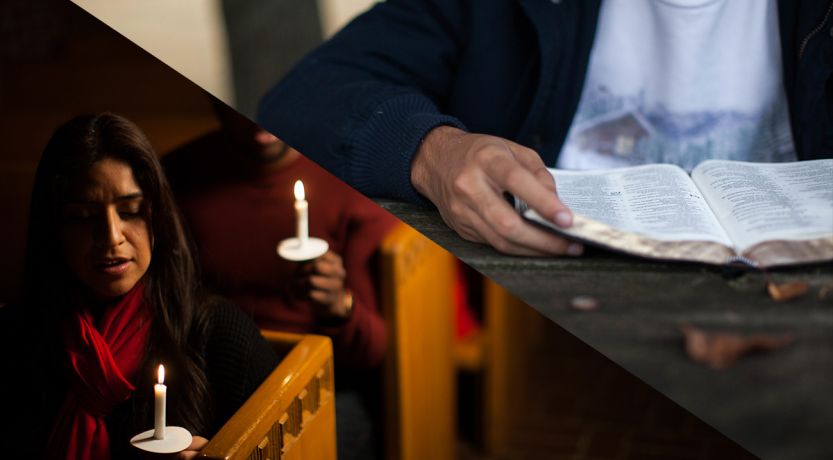 Person reading Bible by candlelight