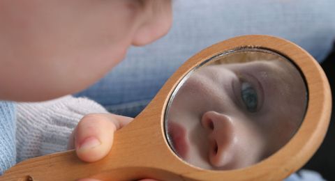 Baby gazing at self in mirror