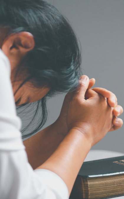 Woman praying with clasped hands