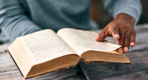 Person reading Bible on table