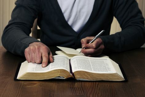 Man writing in Bible