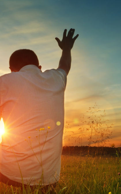 Man kneeling in prayer outdoors