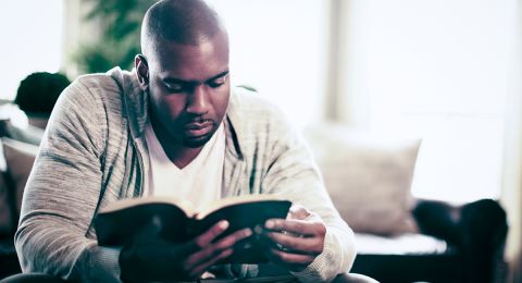 Man reading Bible outdoors