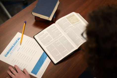 person reading Bible at desk