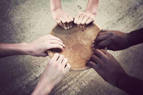 Hands shielding a wooden globe