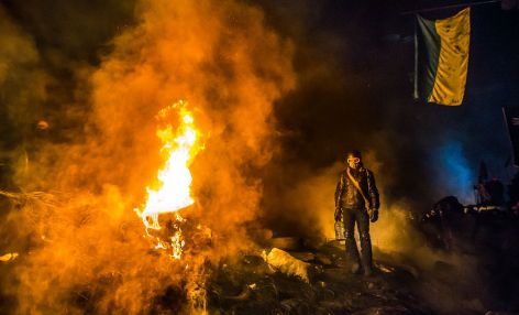 Man protests amid flames in Ukraine