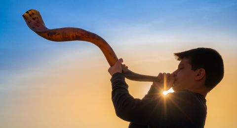 Man blowing traditional ram's horn shofar