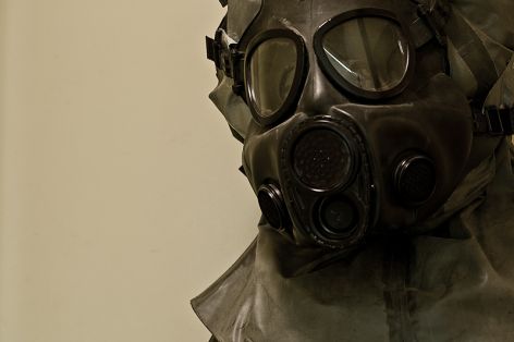 Military gas mask in protective suit