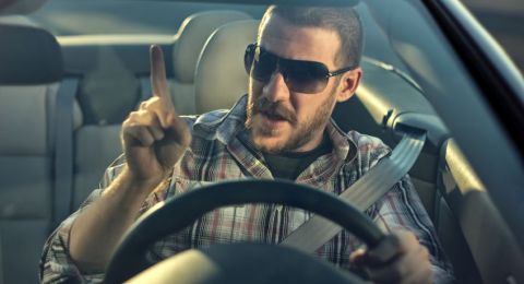 Man gesturing upward in vehicle