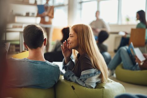 Woman gossiping with coworker