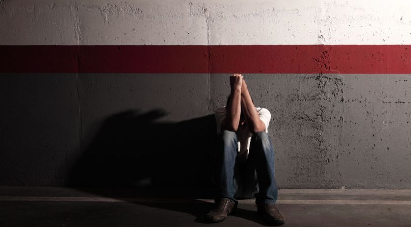 Man brooding in shadowy room