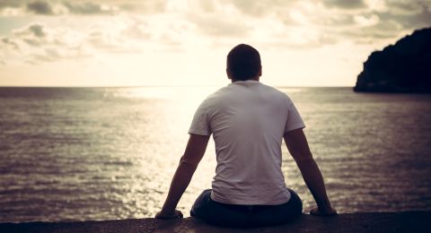 Man contemplating by water's edge