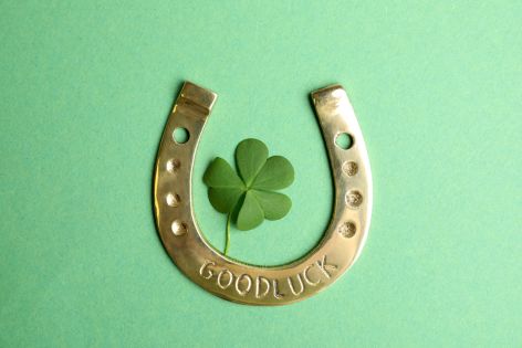 Four-leaf clover beside lucky horseshoe