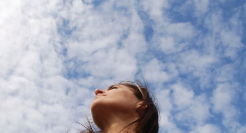 Woman praying outdoors, looking skyward