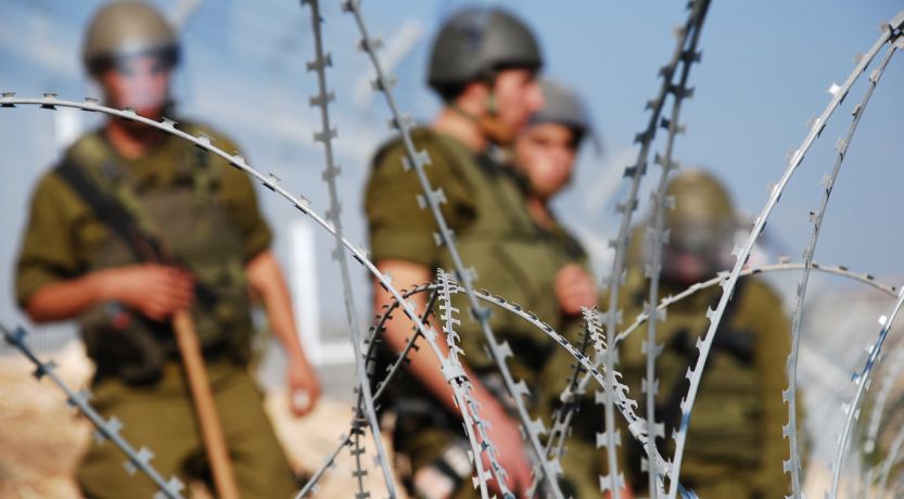 Israeli soldiers behind security fence