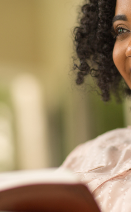 Woman smiling while reading book