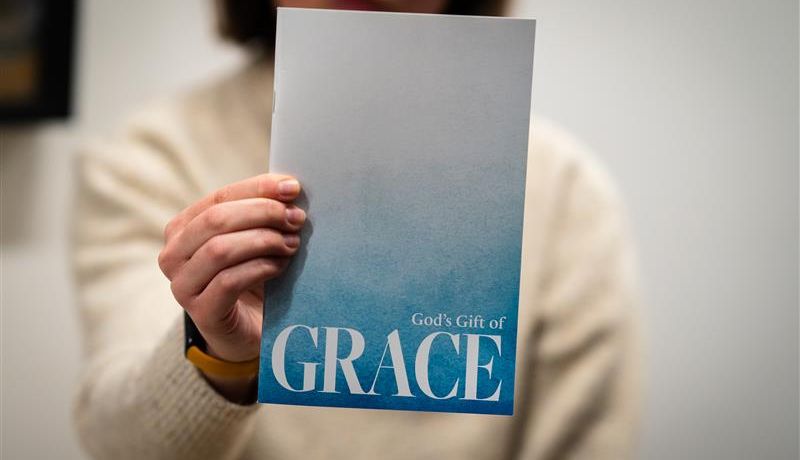 Hands holding grace booklet