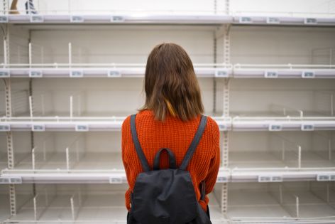 Woman facing empty grocery store shelves