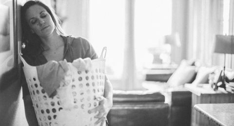 Woman holding basket, grieving indoors