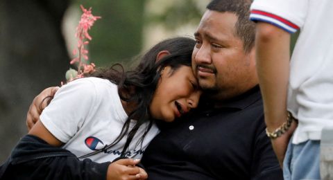 Adult comforting child after school shooting